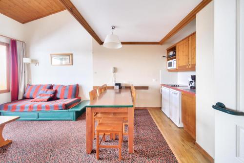 une cuisine et un salon avec une table et un canapé dans l'établissement Résidence La Marelle et Le Rami - maeva Home - Appartement 3 pièces 7 personnes - Sélection MAE-8764, à La Plagne Tarentaise