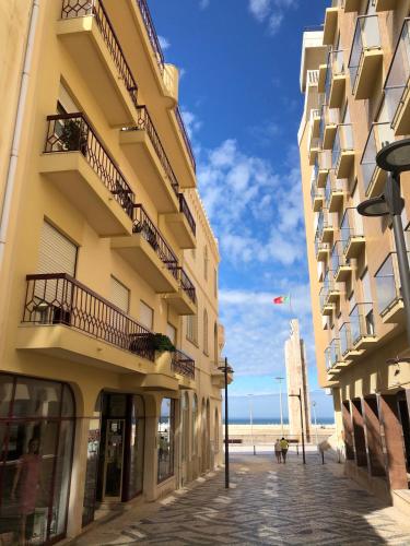 a row of buildings on a street next to the beach at Castelo do Relógio by Férias em Figueira in Figueira da Foz