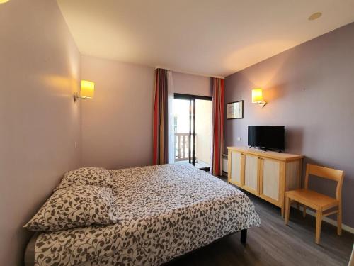 une chambre d'hôtel avec un lit et une télévision dans l'établissement Résidence Centre - maeva Home - Studio 4 personnes - Sélection MAE-9034, à La Rochelle