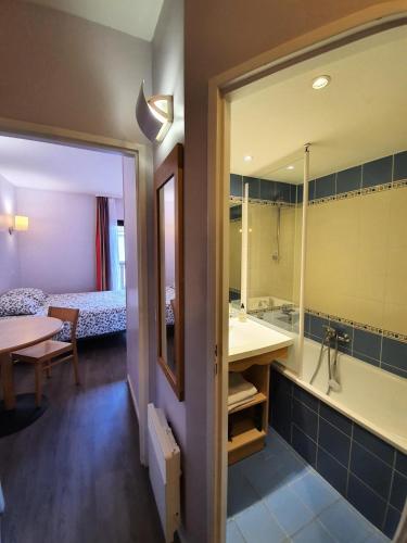La salle de bains est pourvue d'une baignoire et d'un lavabo. dans l'établissement Résidence Centre - maeva Home - Studio 4 personnes - Sélection MAE-9034, à La Rochelle
