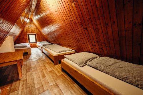 a room with three beds in a wooden cabin at Jánošíková chata Orava in Námestovo