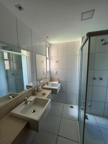a bathroom with two sinks and a glass shower at Apartamento Térreo no Catu Lake Resort Aquiraz in Aquiraz