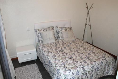 a bedroom with a bed with pillows and a night stand at Appartement au calme. in Thaon-les-Vosges