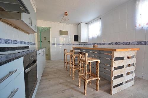uma cozinha com balcão e bancos em Casa de playa en Vilanova de Arousa em Vilanova de Arousa