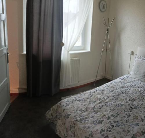a bedroom with a bed and a window with a windmill at Appartement au calme. in Thaon-les-Vosges