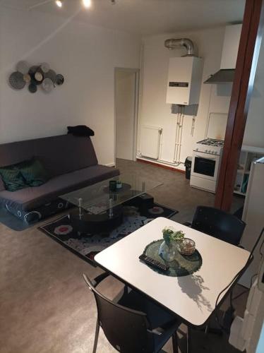 a living room with a table and a couch at Appartement au calme. in Thaon-les-Vosges