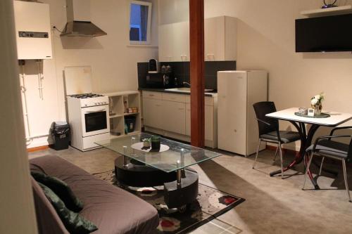 a living room with a couch and a glass table at Appartement au calme. in Thaon-les-Vosges