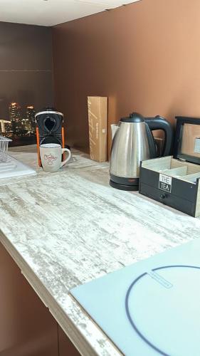 a counter top with a coffee pot and a tea kettle at Très beau studio proche de Disneyland et de Paris in Ozoir-la-Ferrière