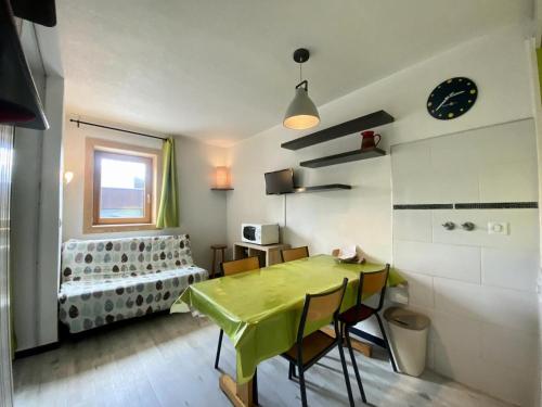 une salle à manger avec une table et des chaises vertes dans l'établissement Résidence Arcelle - Val Thorens centre station, confortable appartement pour 4 personnes MAE-2084, à Val Thorens