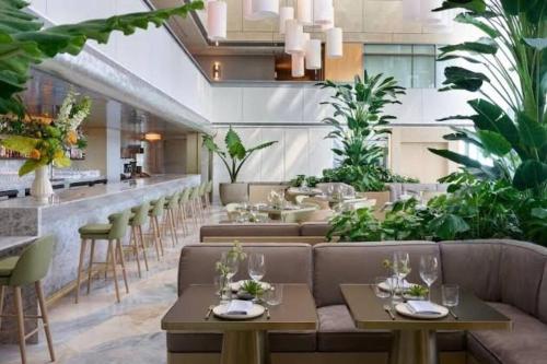 een restaurant met planten en banken en een bar bij AKA Brickell Condo Beautiful Sea View Free Parking by Palermo Home Miami in Miami