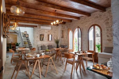 una sala da pranzo con tavoli e sedie in legno di Mansio Boutique Hotel a Rethymno