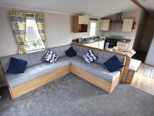 a living room with a couch with blue pillows at Little Vatson in Pembrokeshire