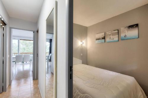 une chambre avec un lit et un miroir dans l'établissement Résidence le Hameau des Issambres - maeva Home - Appartement 3 pièces 4 personnes - Sélection - super Home MAE-4964, aux Issambres