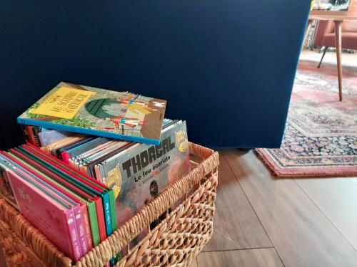 a stack of books in baskets in a room at Spacieux appartement de charme, proche du circuit in Magny-Cours