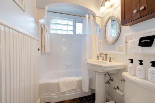 a white bathroom with a shower and a sink at Classic Luxury Tudor And Garden Studio in Oklahoma City
