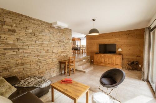 uma sala de estar com uma parede de tijolos em Chalet Lova em Valloire