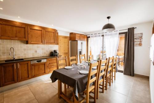 uma cozinha com uma mesa e cadeiras numa cozinha em Chalet Lova em Valloire
