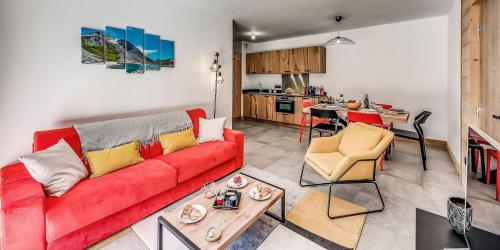un salon avec un canapé rouge et une cuisine dans l'établissement Résidence Les Terrasses De La Vanoise - CASA COLORADO - PREMIUM 4 - Appartement de 4 pièces 8 personnes en rez de chaussée - 72 m2 MAE-1504, à Champagny-en-Vanoise