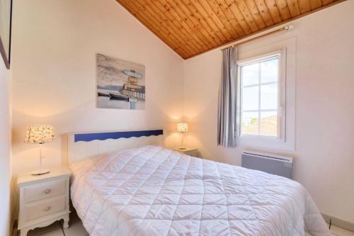 une chambre avec un grand lit et une fenêtre dans l'établissement Résidence Port Bourgenay - maeva Home - Appartement 3 pièces 6 personnes - Sélection MAE-9084, à Talmont-Saint-Hilaire
