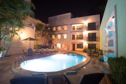 a swimming pool in front of a building at night at Hotel del Gobernador in Mérida