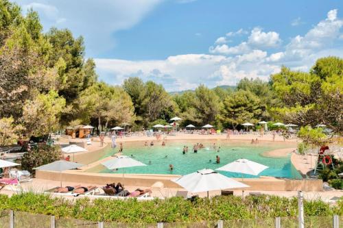 - une grande piscine avec des parasols dans l'établissement Village Pont Royal en Provence - maeva Home - Appartement cosy et climatisé 2 pièces 4 personnes - Prestige - super Home MAE-2164, à Mallemort