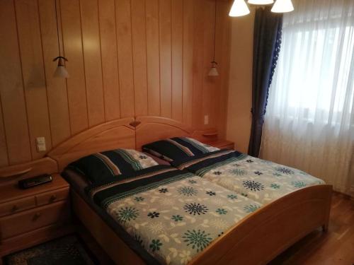 a bedroom with a bed with a wooden head board at Sonnenhäusl in Bergen