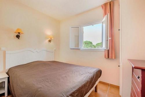 een slaapkamer met een bed en een raam bij Village Pont Royal en Provence - maeva Home - Appartement 3 pièces 6 person 684 in Mallemort