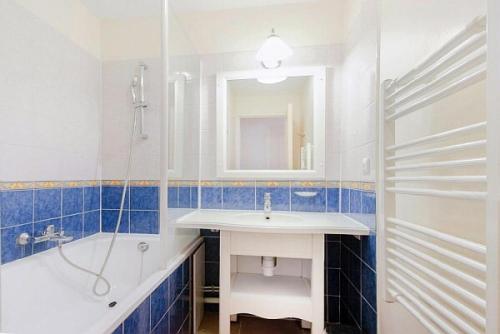een badkamer met een wastafel, een bad en een spiegel bij Village Pont Royal en Provence - maeva Home - Appartement 3 pièces 6 person 684 in Mallemort