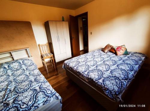 a bedroom with a bed and a chair in it at Casa do pescador, na rota do Cristo Protetor in Estefânia