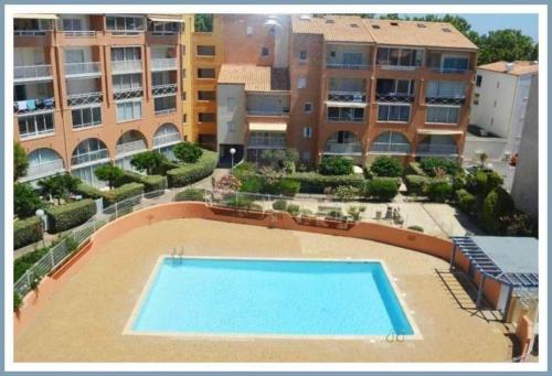 une vue aérienne d'une piscine dans un immeuble dans l'établissement appartement cap d'Agde avec balcon, au Cap d'Agde