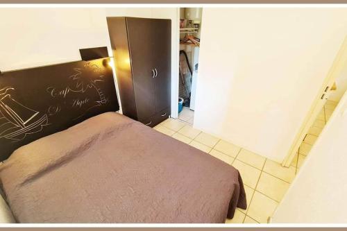 une petite chambre avec un lit dans une pièce dans l'établissement appartement cap d'Agde avec balcon, au Cap d'Agde