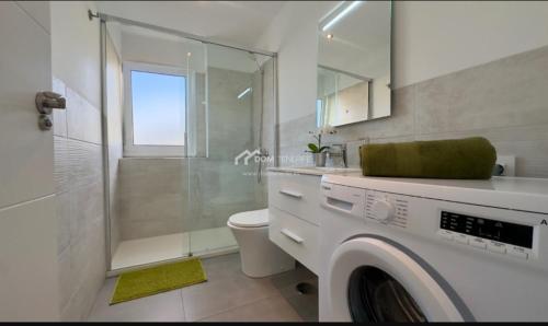 a bathroom with a shower and a washing machine at Penthouse Apartment Las Americas in Playa de las Americas