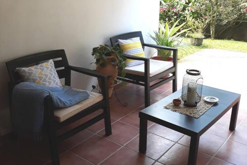 un patio con 2 sillas, una mesa y una planta en Maison d'une chambre avec terrasse et wifi a Fort de France, en Fort-de-France