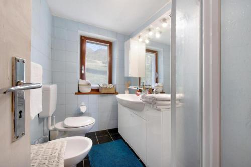 La salle de bains blanche est pourvue de toilettes et d'un lavabo. dans l'établissement Alpine Majestic Escape - Balcone sulle Piste di Sci, à Champoluc