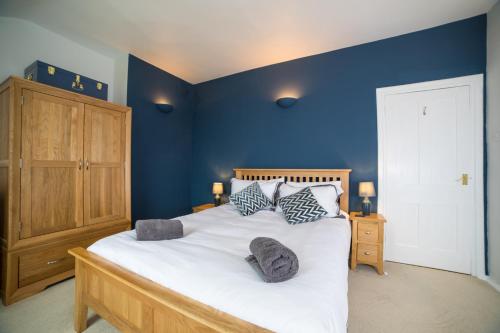 Un dormitorio con una cama grande con paredes azules. en Fort Victoria Cottages - Spinnakers, en Yarmouth