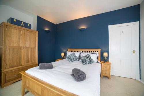 a bedroom with a large bed with blue walls at Fantastic sea views and amazing coastal scenery in Yarmouth