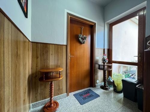 un couloir avec une porte en bois et un tabouret en bois dans l'établissement Ca' della Valle - trilocale nel cuore delle Alpi Piemontesi, à Villadossola