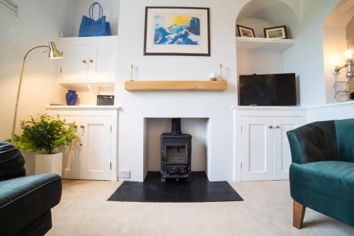 a living room with a fireplace and a tv at Fort Victoria Cottages - Spinnakers in Yarmouth