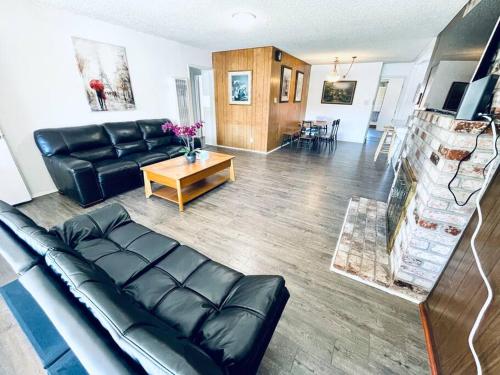 a living room with a black leather couch and a table at 202 Spacious Hayward Entire 4BR SFH in Hayward