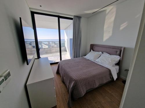 a small bedroom with a bed and a window at Luxury Private Apartments - Limassol in Limassol