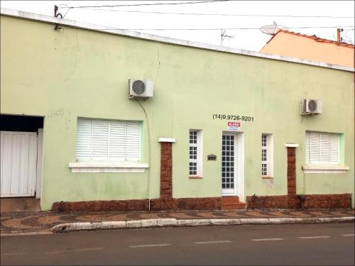 ein grünes Gebäude an der Straßenseite in der Unterkunft Suíte privativa Gigá in Brotas