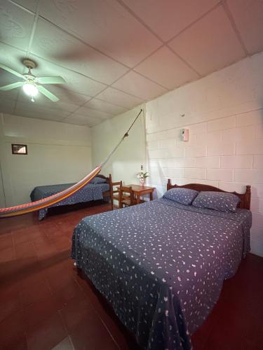 a bedroom with a bed and a hammock in it at Hotel y Restaurante El Cafetalito in Conchagua