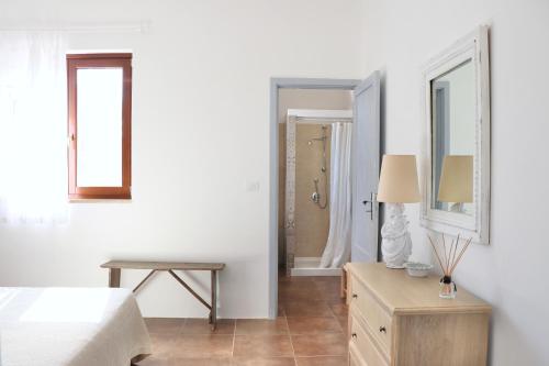 een slaapkamer met een bed, een tafel en een spiegel bij Trullo a ll'éra in Ceglie Messapica