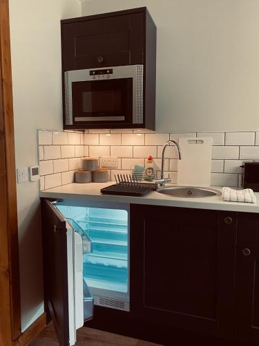 a kitchen with a sink and a microwave at Ben Nevis Inn Rooms in Fort William