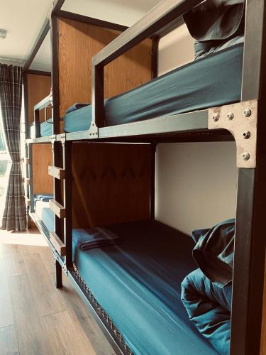 two bunk beds in a room with blue sheets at Ben Nevis Inn Rooms in Fort William