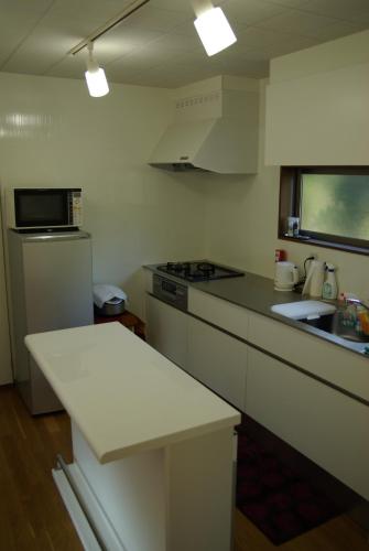 a kitchen with a white counter top and a sink at Den House in Oshima