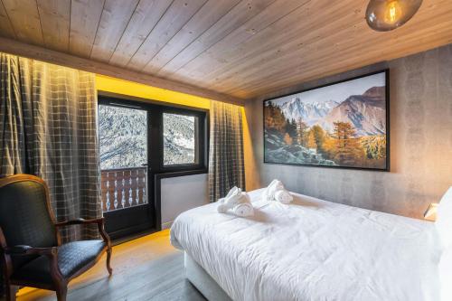 a bedroom with a bed and a large window at Chalet Les Morilles - Chalets pour 10 Personnes 054 in Les Allues