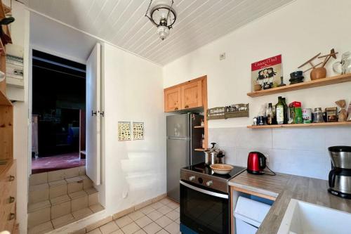 une cuisine avec un évier et un réfrigérateur dans l'établissement Charmante maison de pêcheur 6p, à pied de la mer, à Penvénan