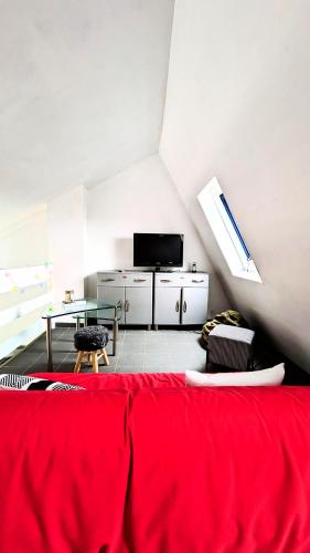 un salon avec un canapé rouge et une table dans l'établissement Seventies house Houlgate, à Houlgate