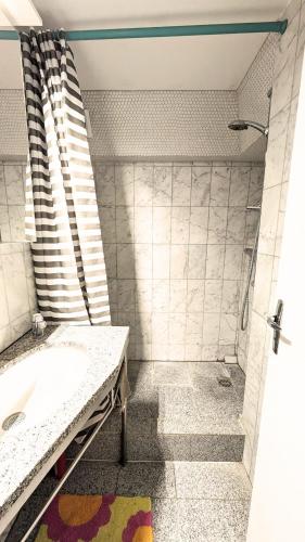 une salle de bain avec un lavabo et une douche dans l'établissement Seventies house Houlgate, à Houlgate